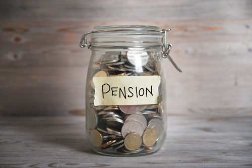 'Pension' taped on a glass jar of coins. 