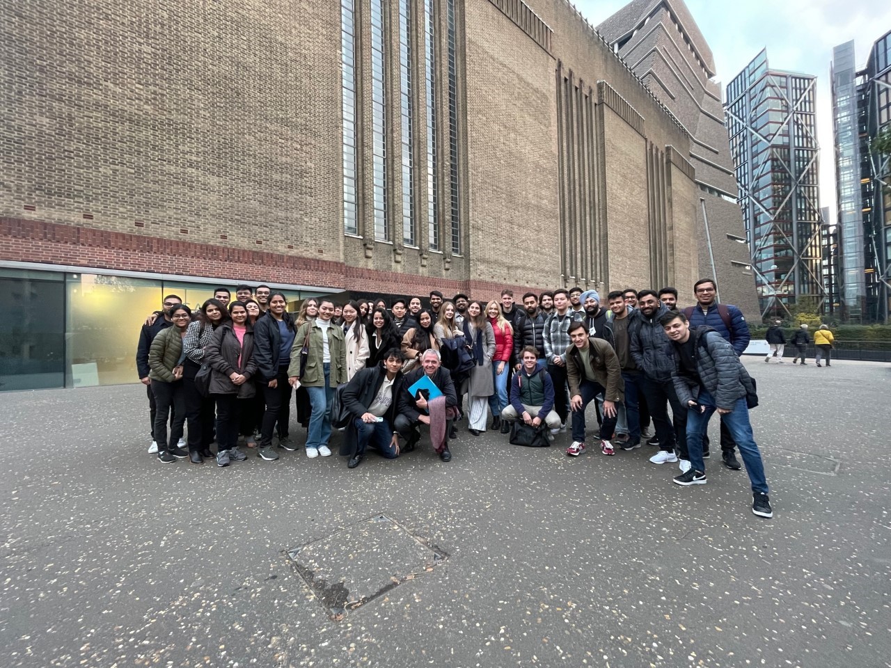 Students gather and smile outside Tate Modern