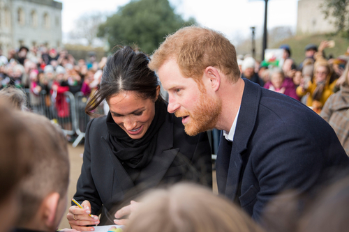 Prince Harry and Meghan Markle sign pictures