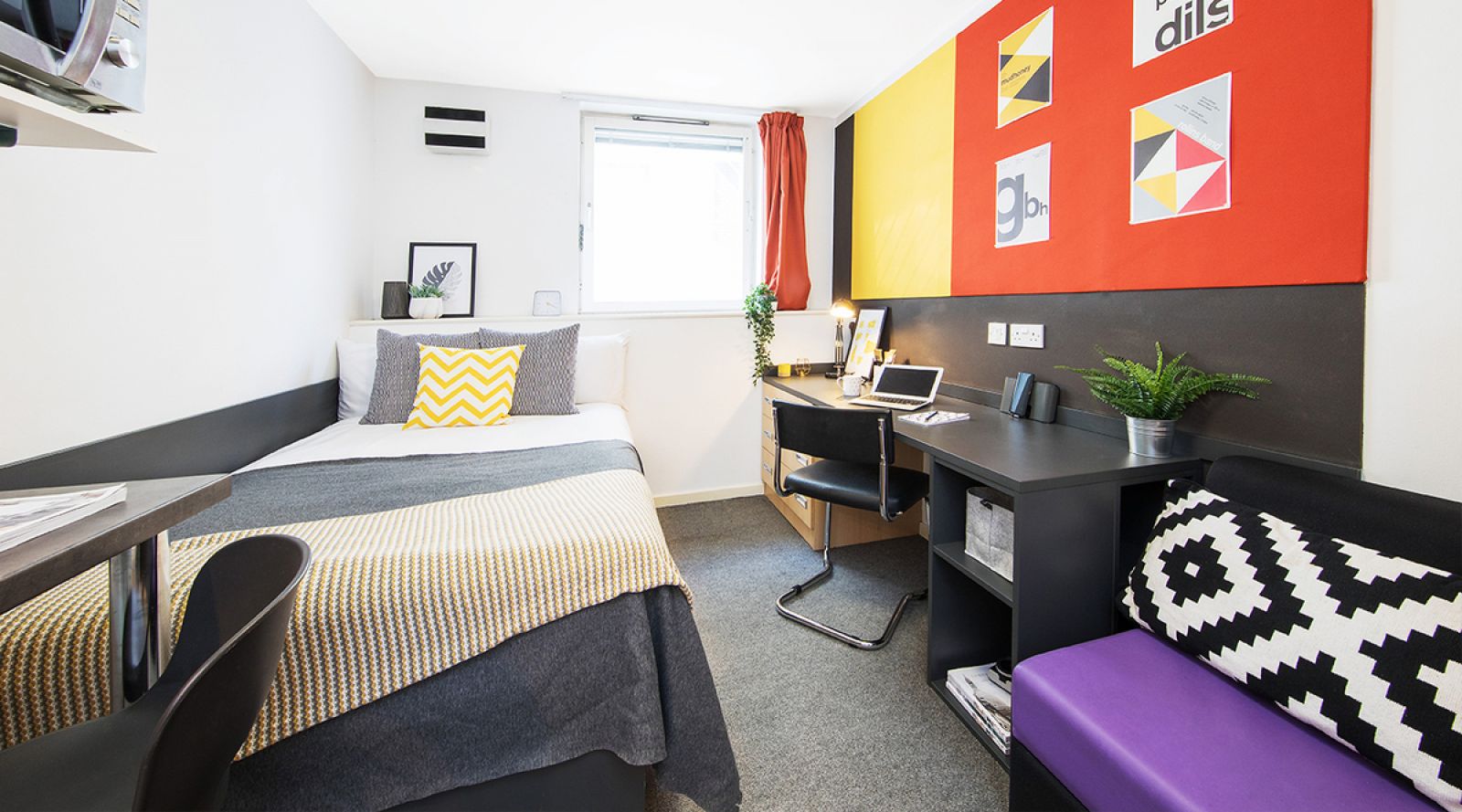 Student residential halls bedroom interior, with a neatly made bed and a desk.
