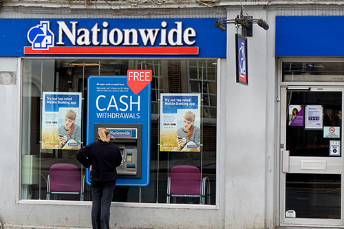 Woman withdraws cash from a Nationwide building society ATM