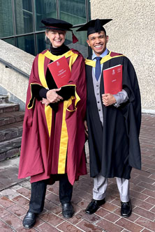 MICL Alumni Daniel Liendo standing in graduation gown with Dr Sara Jones