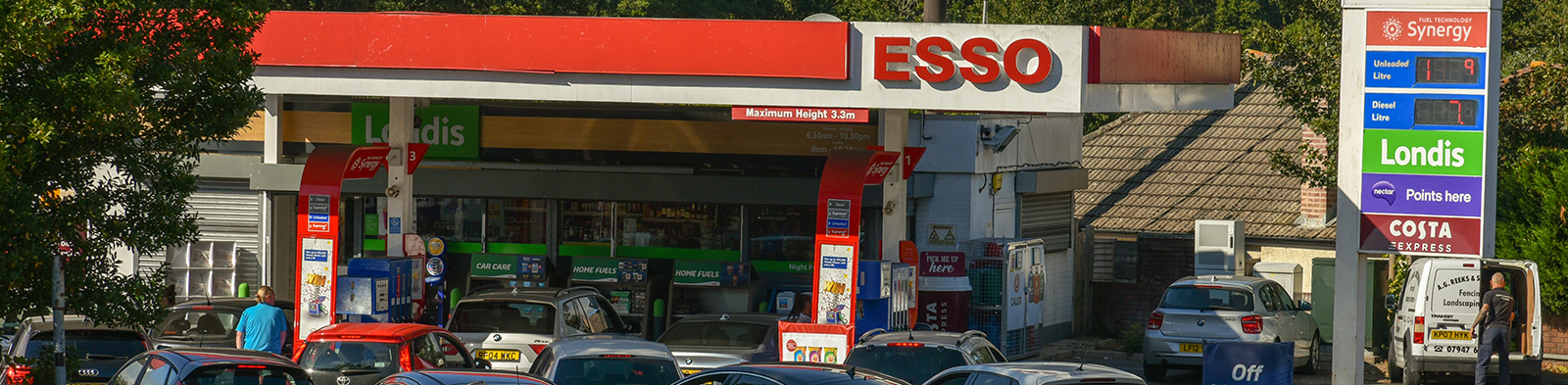 Cars queuing at a petrol station along the road