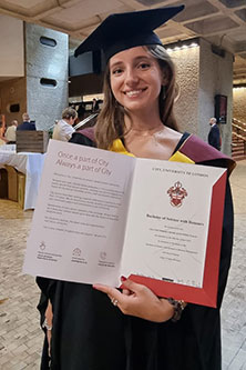 Lila Vialat holds her graduation certificate