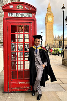 MICL alumni Daniel Liendo standing in front of the red phone box on the street across Big Ben in London