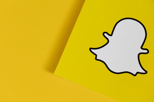 Snapchat logo on yellow paper.