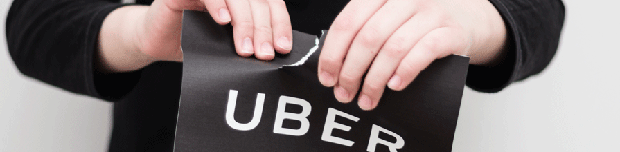 Person ripping Uber logo