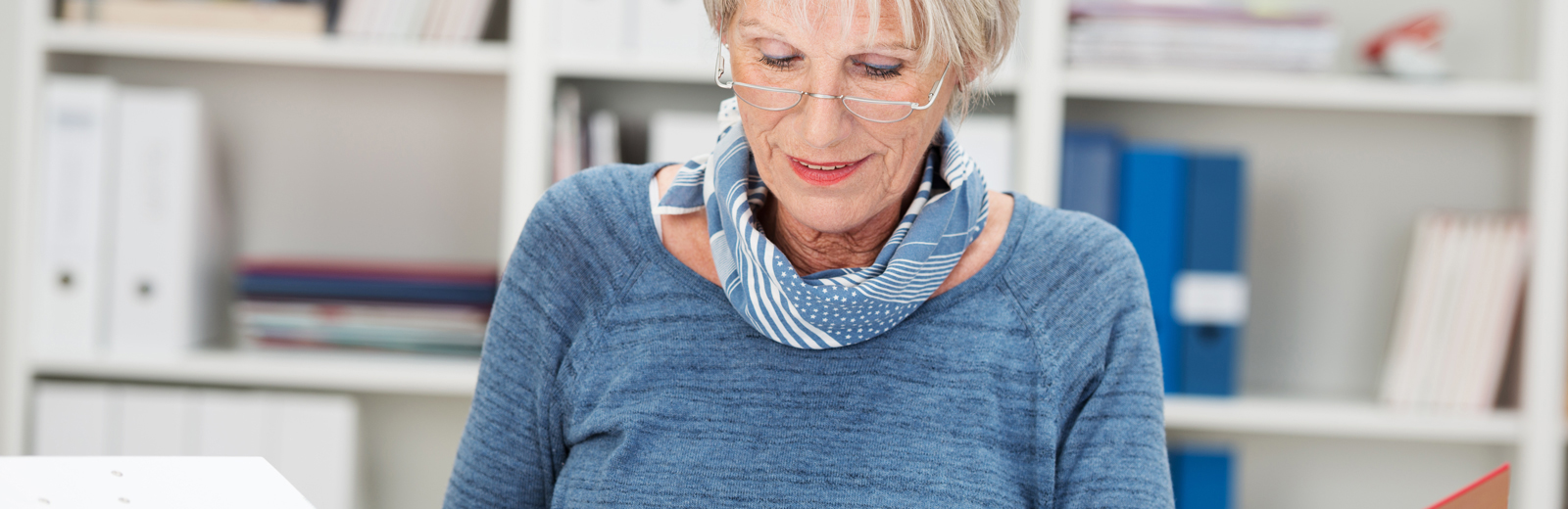 Older woman looks down at papers