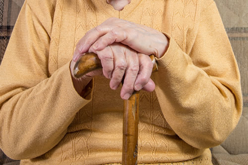 A pensioner holding a cane