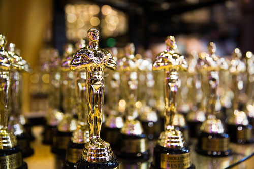 A line up of shining gold Oscars award statues.
