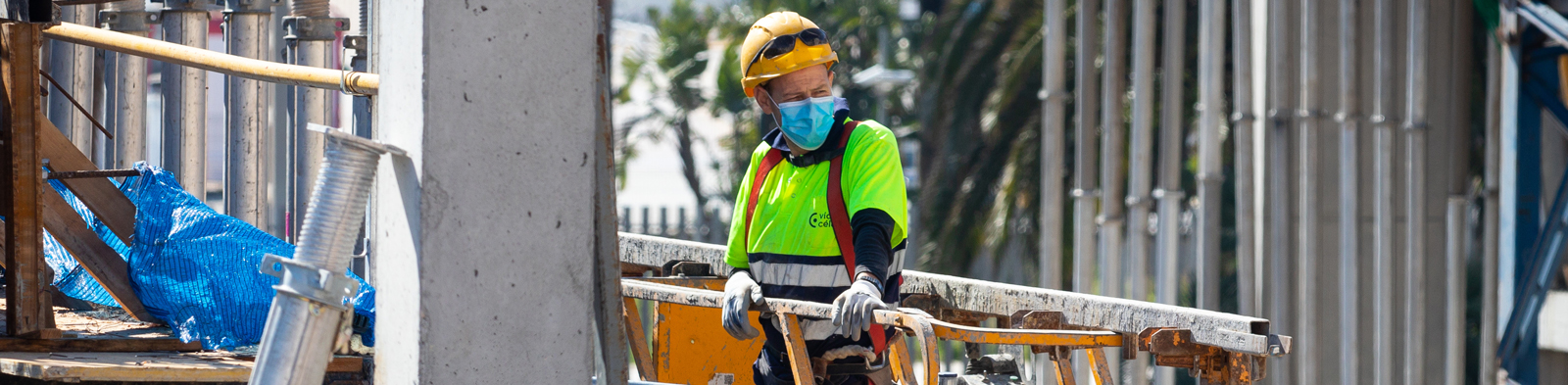 worker on building site with hi-vis jacket and face mask