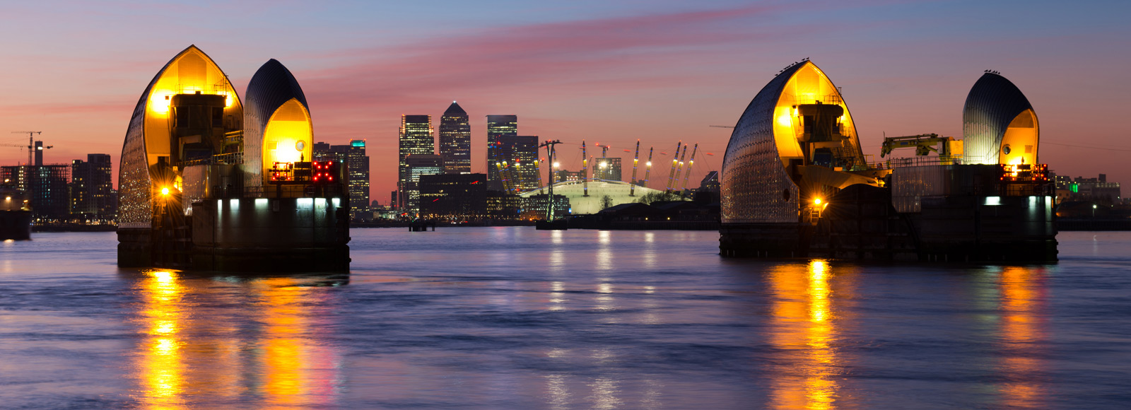 Thames flood barrier and view of Canary Wharf at night