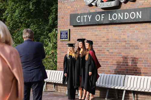 Three female Bayes graduates pose at The Barbican Centre