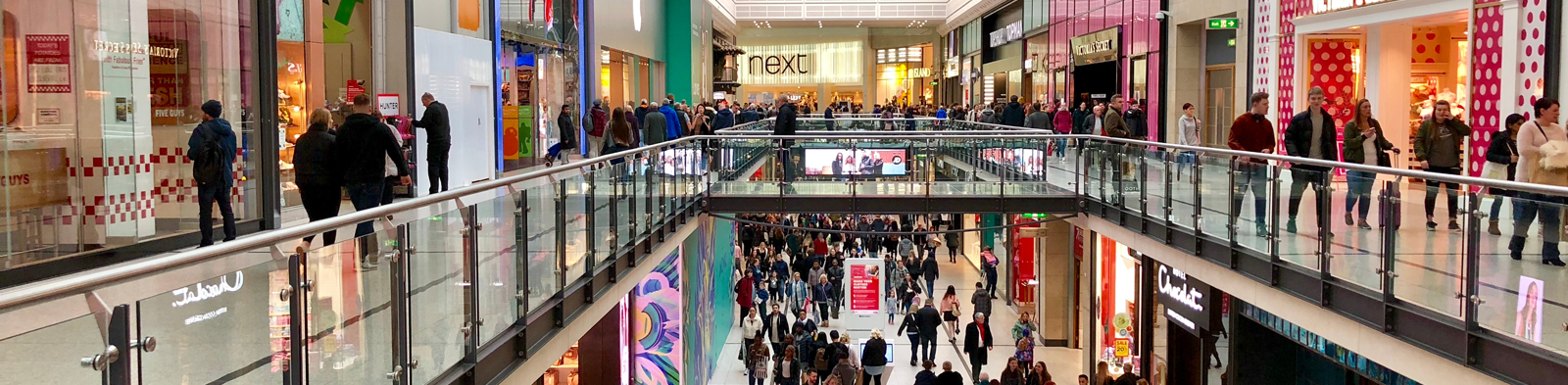 people walking through a crowded shopping centre