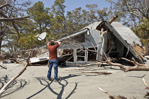 man in front of demolished house