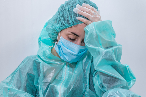 stressed doctor in protective clothing sits on the floor