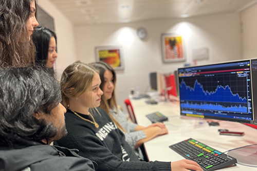 Elena Kastellanou and her team around a screen in the Bloomberg Trading Room at Bayes Business School